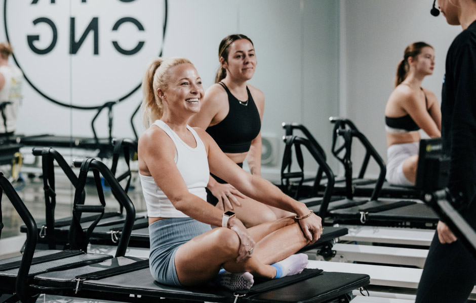 Member sitting on a reformer before class